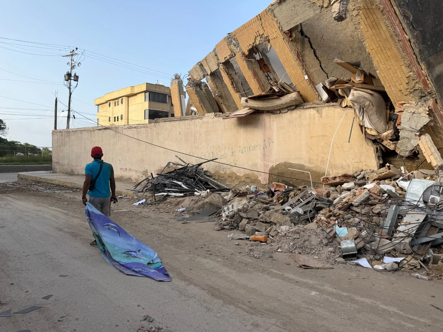 Un hombre transita por los restos del edificio donde aún buscaban personas.